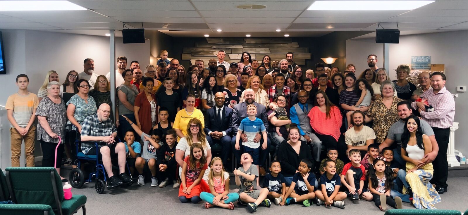 The full Freedom House Church congregation, adults standing in back and children seated in front, gathers for a group photo in the sanctuary.